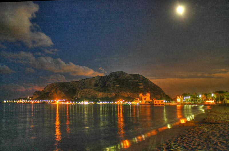 Spiaggia di Mondello illuminata di notte durante l'estate